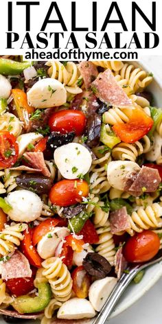 a bowl filled with pasta salad on top of a marble countertop next to a fork