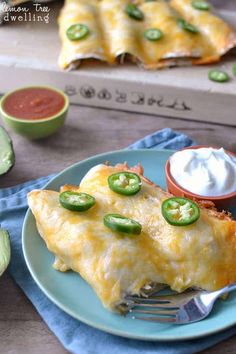 a piece of enchilada on a plate with a fork next to it