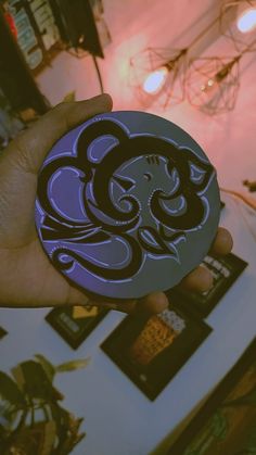 a person holding up a purple and black sticker with an octopus design on it