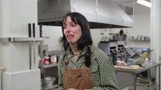 a woman standing in a kitchen with an apron on