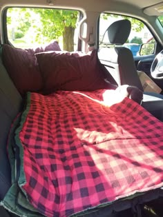 the dog is sleeping in the back seat of the truck with his head on the pillow