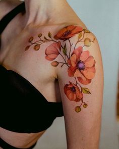 a woman's shoulder with flowers painted on it