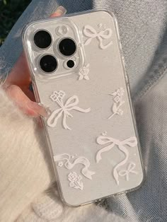 a person holding an iphone case with bows on it