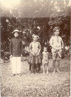 an old black and white photo of three people standing next to each other in the grass