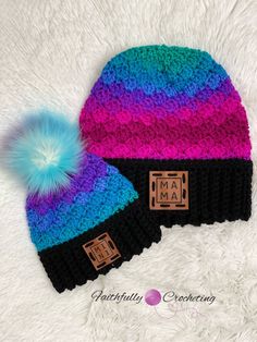 two knit hats with blue, pink and purple pom - poms on top