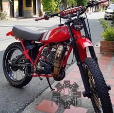 a red motorcycle is parked on the sidewalk