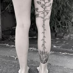 a woman's legs with tattoos and flowers on them