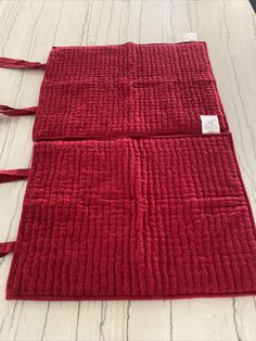 three red rugs with ties on them sitting on top of a white tablecloth