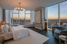 a bedroom with large windows overlooking the city