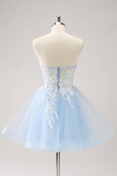 a light blue dress on a mannequin with white lace and flowers in the skirt