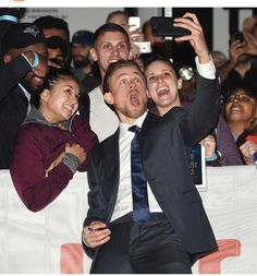 a man in a suit and tie taking a selfie with his friends at an event