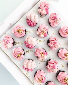 there are many cupcakes that have pink frosting on them and gold sprinkles