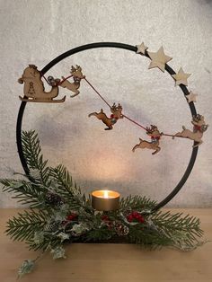 a christmas decoration with reindeers and sleigh hanging from the hoop on a table