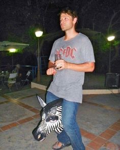 a man standing next to a statue of a zebra on top of a tiled floor