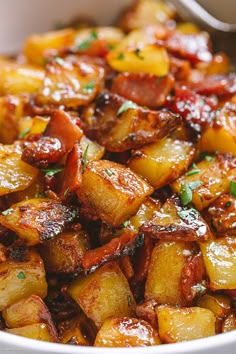 a white bowl filled with cooked potatoes and bacon