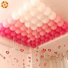 a room filled with lots of pink and white balloons