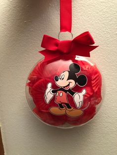 a red ornament with a mickey mouse design on it's side hanging from a wall