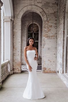 a woman in a white wedding dress posing for the camera