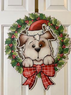 a dog with a santa hat and bow hanging on a door