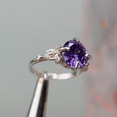 a close up of a ring with a purple stone