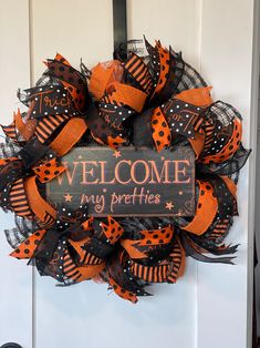 a welcome sign is attached to the front door for someone's special halloween wreath