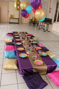 the table is set up for a party with balloons