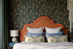 a bed with blue and green wallpaper in a bedroom