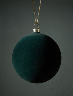 a green ornament hanging from a gold chain