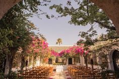 an outdoor ceremony setup with chairs and pink flowers