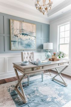 a blue and white living room with a large painting on the wall