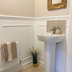 a bathroom with a sink, towel rack and toilet paper roll on the wall next to it