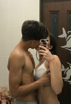 a man and woman taking a selfie in the bathroom