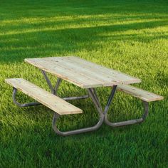 a picnic table in the grass with two benches underneath it and one bench on each side