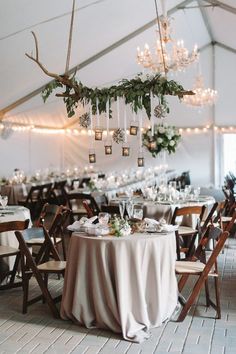 an image of a tent with tables and chandeliers hanging from it's ceiling