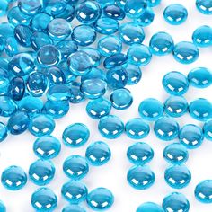 blue glass beads are scattered on a white surface