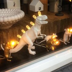 three lighted dinosaurs in a window display