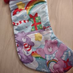 a colorful stocking with teddy bears on it sitting on a wooden floor next to a wall