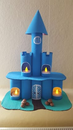 a birthday cake made to look like a castle with candles in the front and side