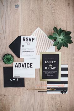 the wedding stationery is laid out on top of the wooden table with succulents