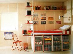 a child's bedroom with a bed, desk and storage bins on the wall