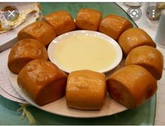 a white plate topped with rolls next to a bowl of dip