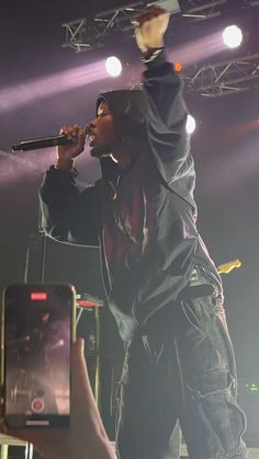 a man standing on top of a stage holding a microphone