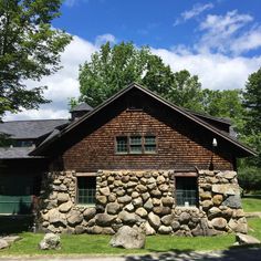 an old log cabin with large rocks on the front