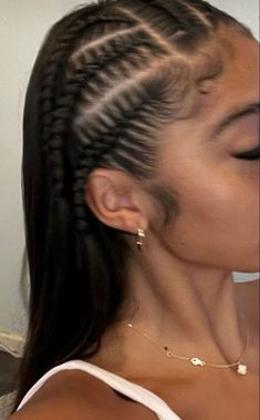 a woman with braids in her hair is looking down at the camera while wearing a white tank top