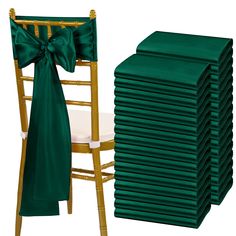 a stack of green chair covers next to a stack of gold chairs