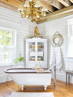 a bathroom with a claw foot tub and chandelier in the middle of it