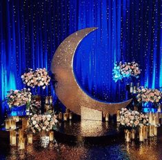 an image of a blue and gold stage with flowers on the moon next to it