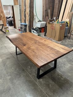 a large wooden table sitting on top of a cement floor next to some wood planks