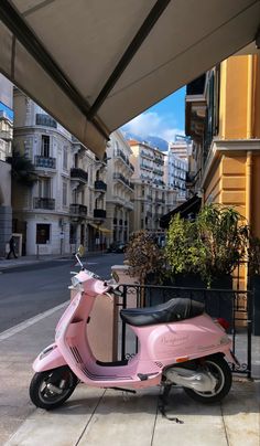 a pink scooter is parked on the sidewalk