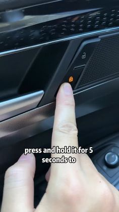 a person is pressing the button on a car's stereo system to press and hold it for 5 seconds